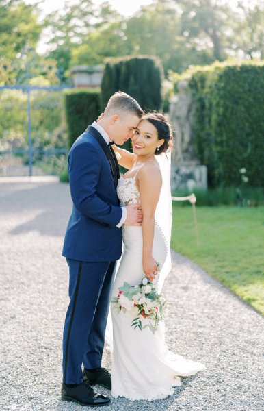 Bride groom exterior veil garden holding hands flowers bouquet