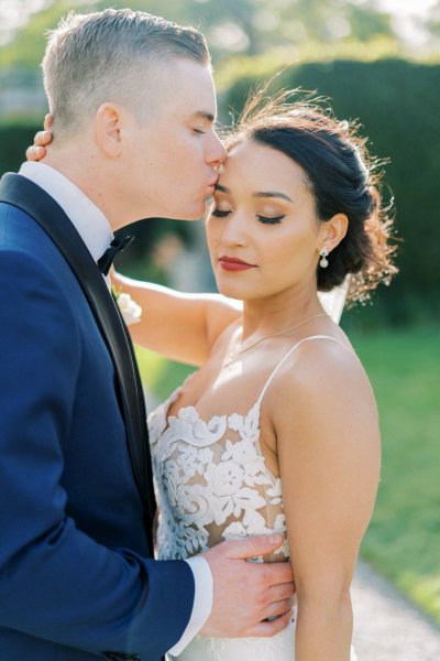 Bride groom exterior veil garden holding hands flowers bouquet close up