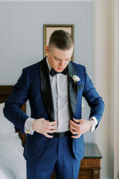 Groom getting ready white flower suit