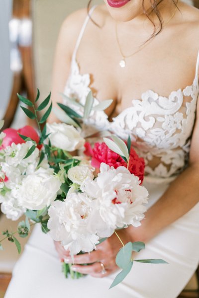 Bride smiles happy holding bouquet of flowers