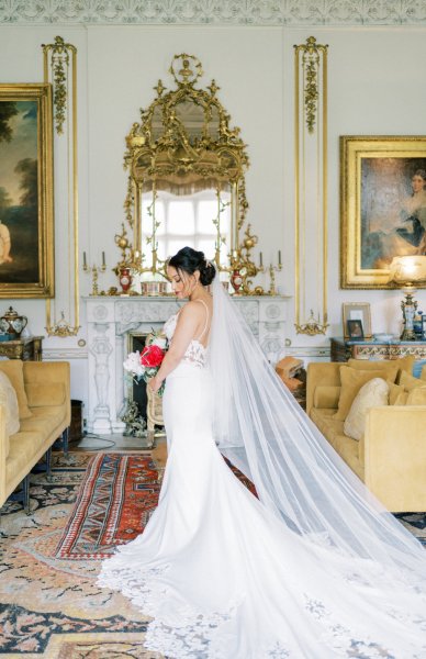 Bride holding white red roses bouquet dress detail