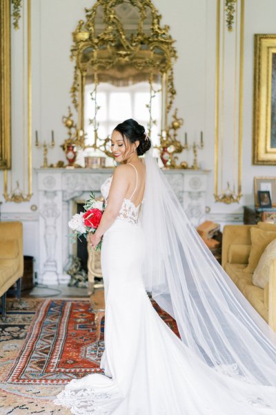 Bride holding white red roses bouquet dress detail