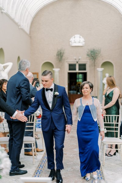 Blue suit tie white rose mother aisle