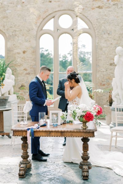 Bride groom wedding ceremony flowers guests aisle