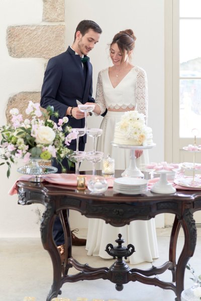 Bride and groom cutting cake knife champagne glasses