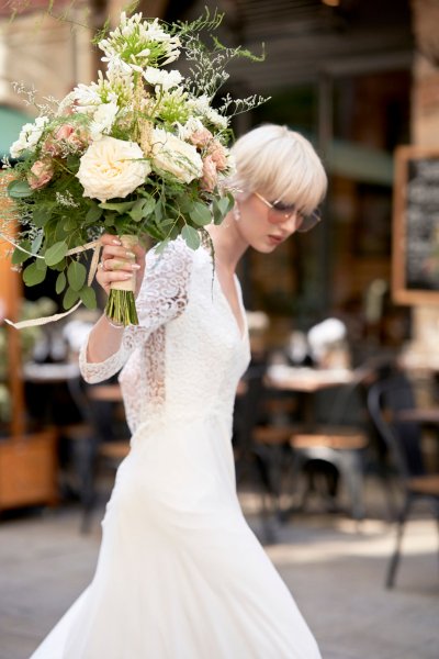 Bride wedding dress lace on her own street style sunglasses glasses bouquet flowers