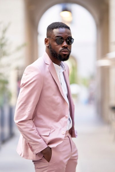 Groom pink suit standing in street sunglasses glasses