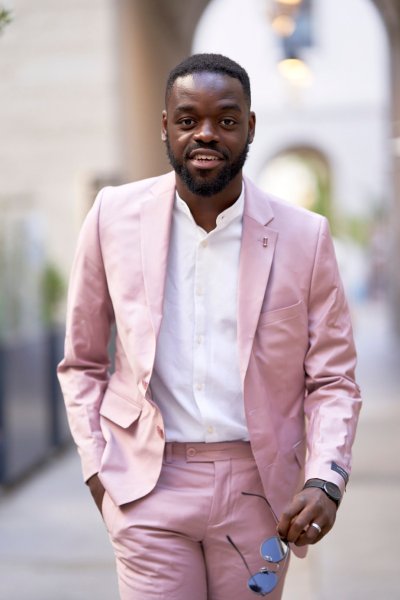 Groom pink suit standing in street sunglasses glasses