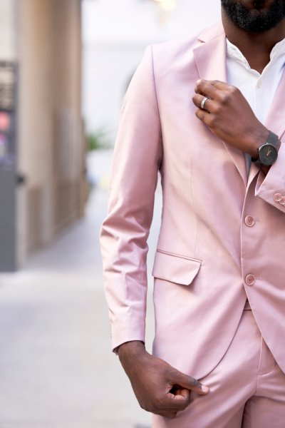 Groom pink suit standing in street sunglasses glasses