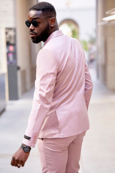 Groom pink suit standing in street sunglasses glasses