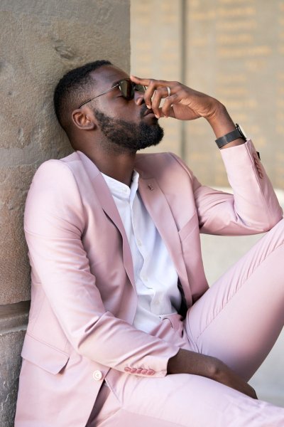 Groom pink suit standing in street sunglasses glasses