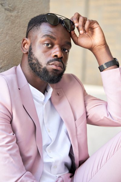 Groom pink suit standing in street sunglasses glasses