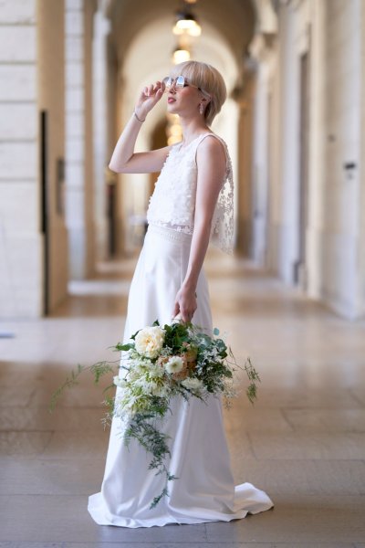 Bride wearing sunglasses holding bouquet of flowers