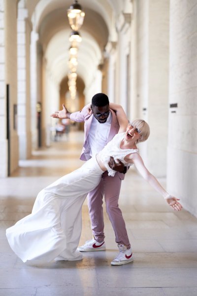 Bride groom pink suit playful