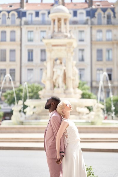 Back to back bride groom in front of fountain flowers bouquet