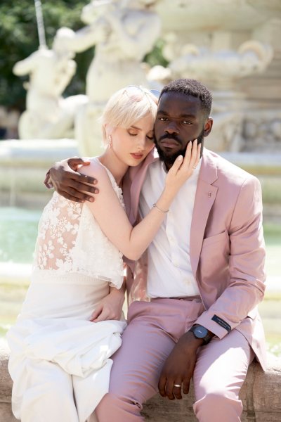 Bride groom pink suit at fountain