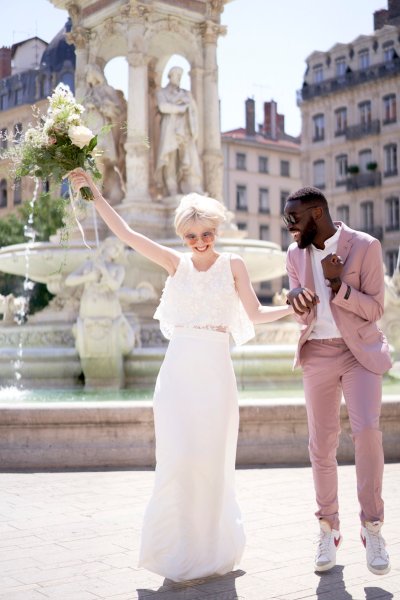 Bride groom laughing at fountain bouquet of flowers