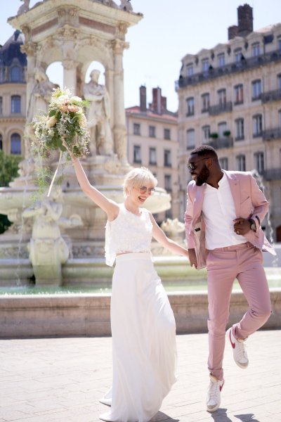 Bride groom laughing at fountain bouquet of flowers