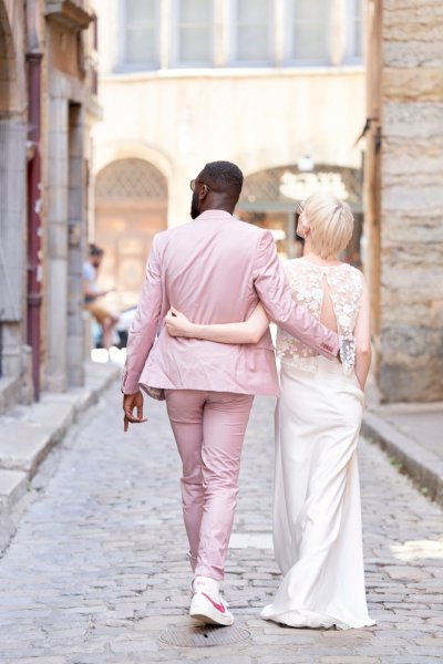 Bride groom pink suit lace dress walking down street