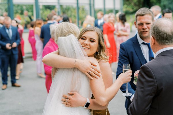 Guests and bride talk hug