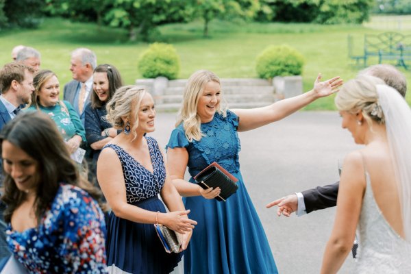 Guests and bride talk hug embrace