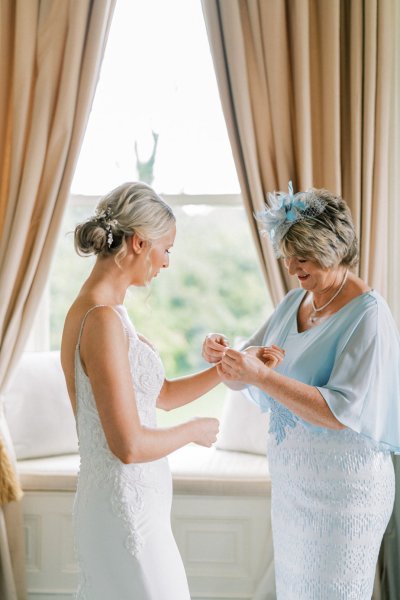 Bride and mother blue gown hat getting ready