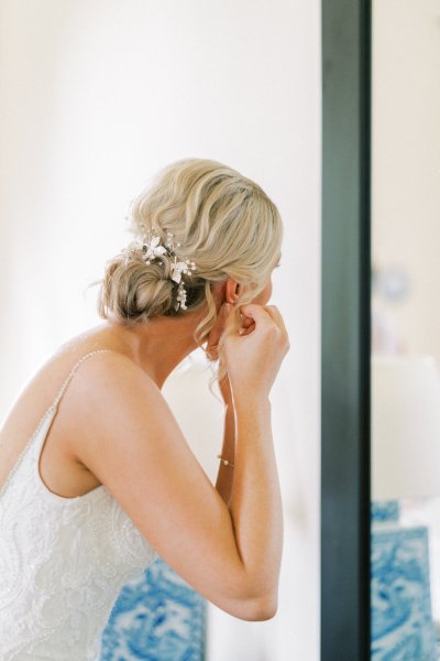 Bride hairstyle putting on earrings