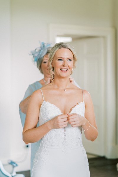 Bride and mother blue gown hat getting ready