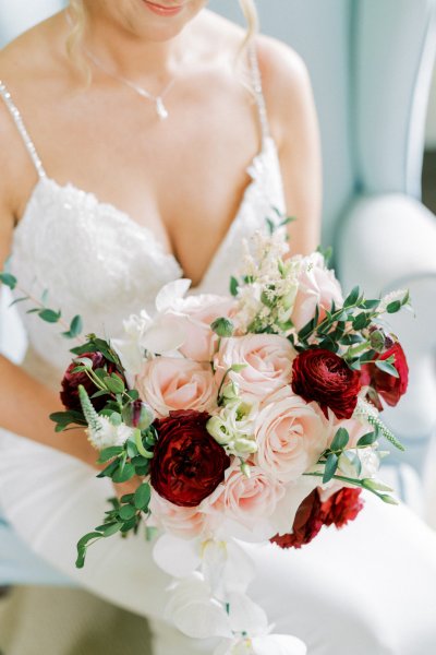 Bride hold pink red roses bouquet of flowers