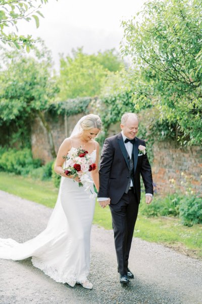 Bride groom flowers pink red bouquet walking