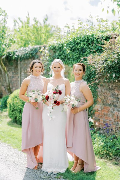 Bride bridesmaids holding roses bouquet of flowers