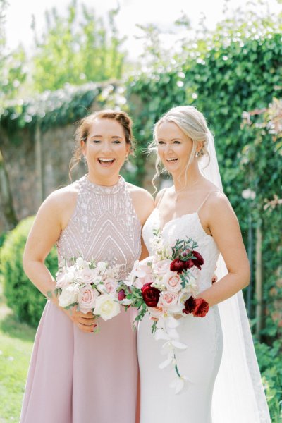 Bride bridesmaid holding roses bouquet of flowers