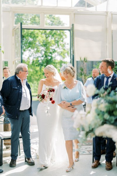 Bride mother walking down the aisle at wedding ceremony