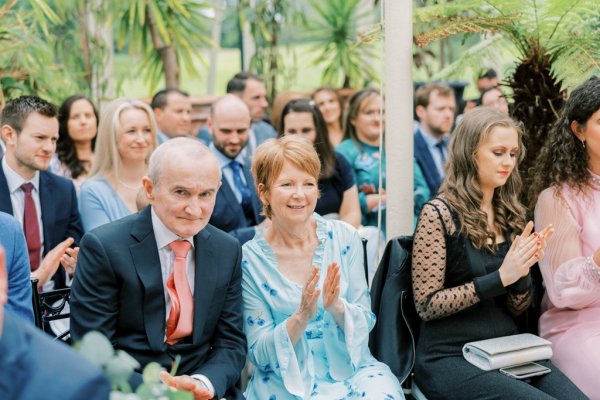 Guests clap celebrating newly wed couple