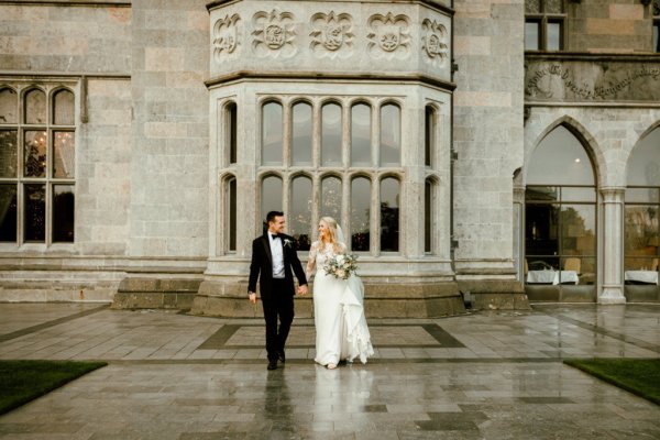 Bride groom outside rainy day venue flowers bouquet