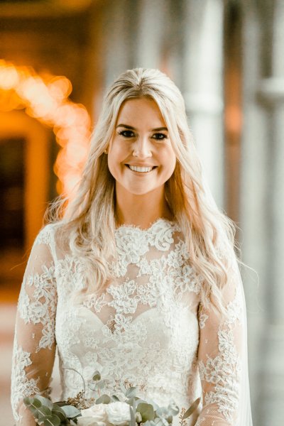 Bride on her own lace bridal gown dress smiling