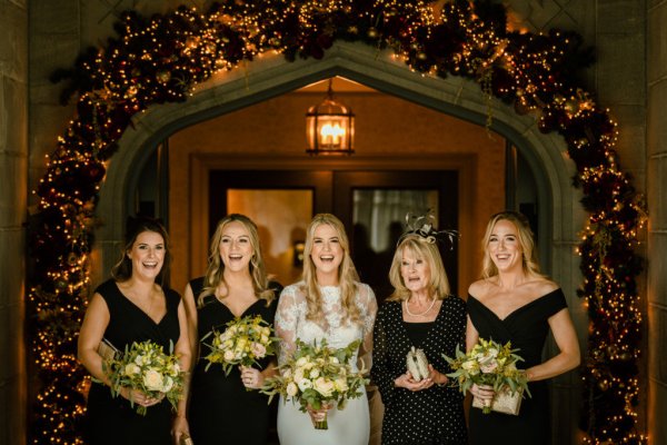 Bride and bridesmaids holding bouquet of flowers