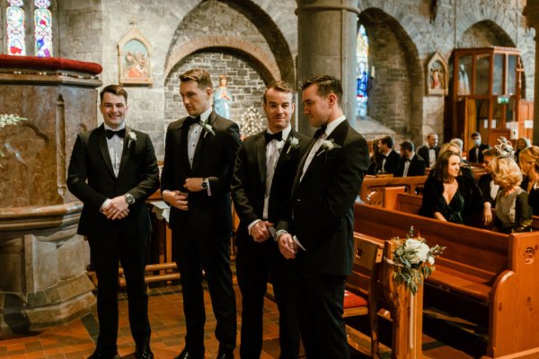 Groomsmen groom guests pew flowers