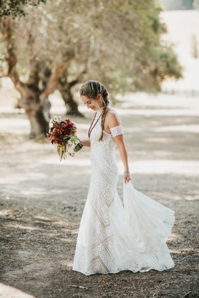 first look Bride on her own holding bouquet flowers forest park