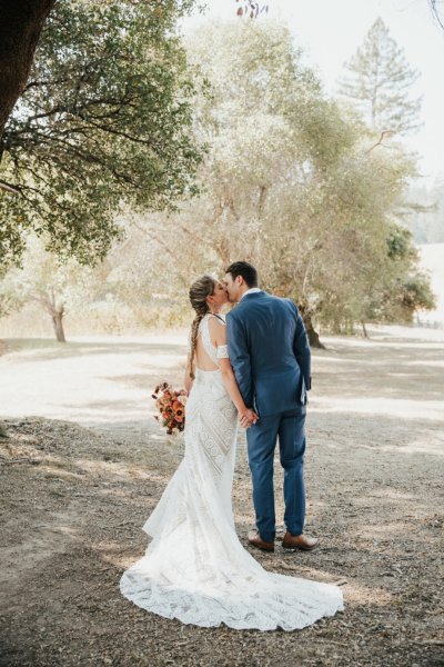 Bride groom forest park tree sunshine bouquet flowers hay field standing behind