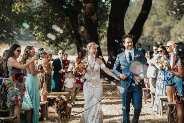 Bride groom exit just wed dog guests flowers bouquet