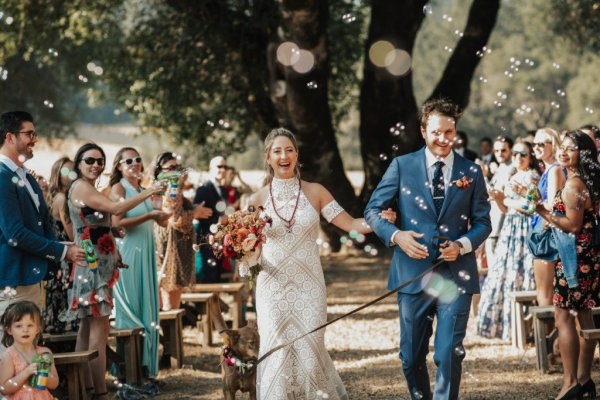 Bride groom exit just wed dog guests flowers bouquet