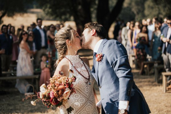 Bride groom kiss guests flowers bouquet