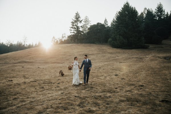 Bride and groom embracing flowers rose bouquet park forest hand in hand holding hands