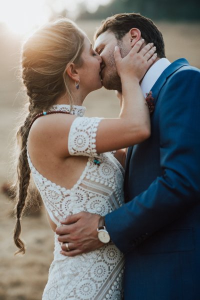 Bride and groom embracing flowers rose bouquet park forest kissing kiss