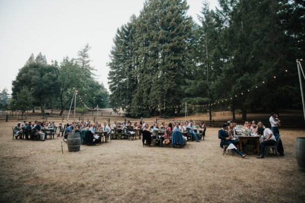 Guests sitting down in groups outside in park