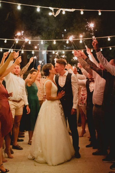 Couple kiss in front of guests lights clapping