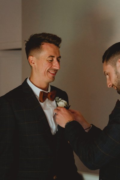 Groom and groomsman best man getting ready flower suit detail