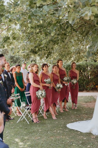 Bridesmaids stand ceremony bouquet of flowers