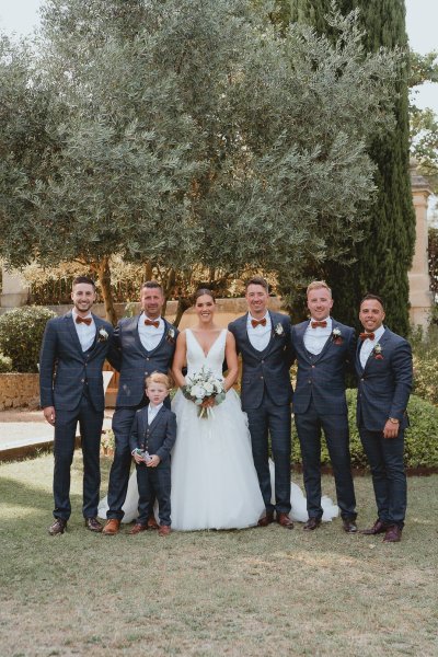 Groomsmen bride groom child flowers